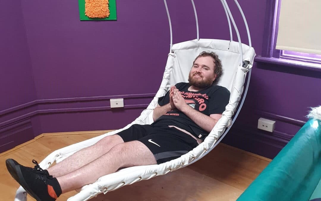 Afford client laying on swinging leaf chair at ashfield community centre