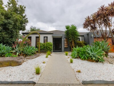 Large SIL house with pebbled front garden and cactus plants.