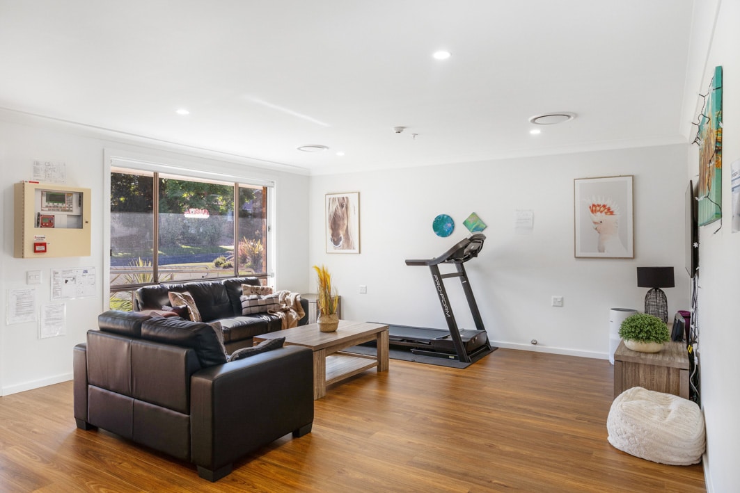 Living room with a treadmill, coffee table and two sofas