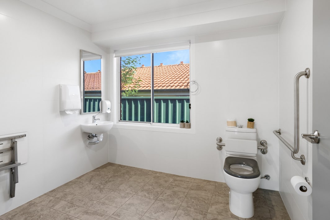 Accessible bathroom with a toilet and grab rail