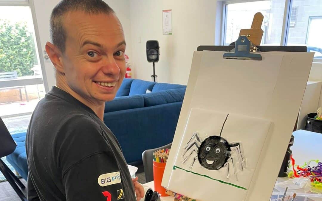 Ian at Afford's Holden Hill Community Centre creating a painting of a spider.