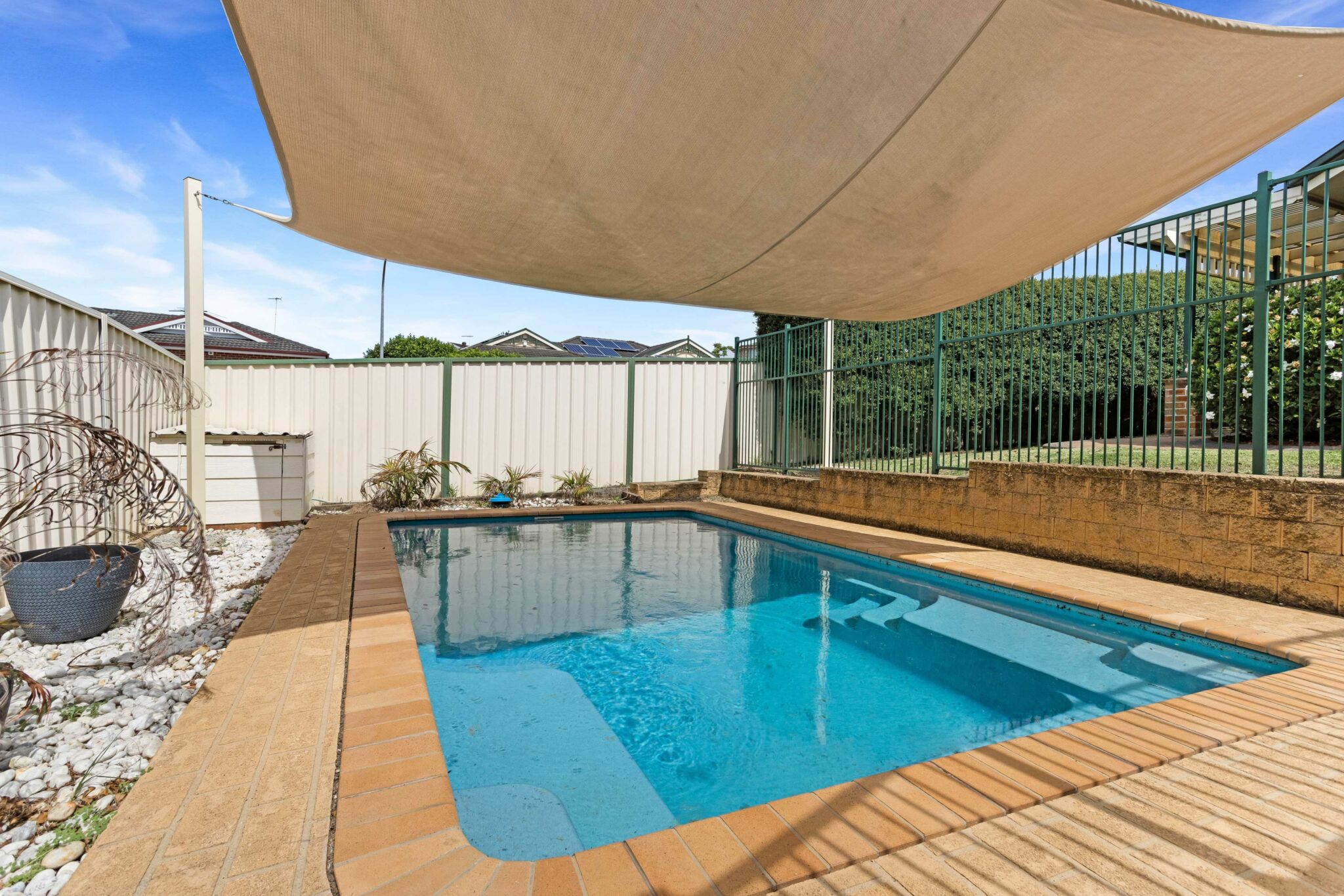 Undercover outdoor swimming pool with a safety fence.