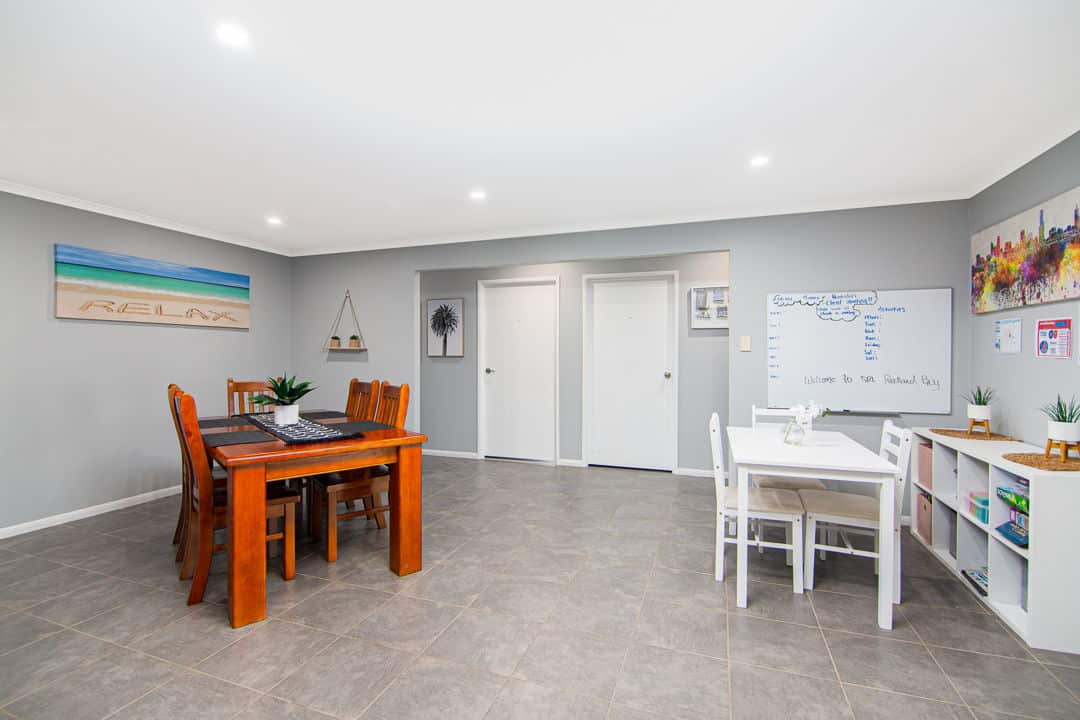 Large dining room with a dining table and chairs on one side of the room and a smaller table and chairs on the other side.