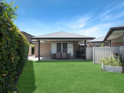 Grassed garden in a SIL house with a shaded outdoor dining area.