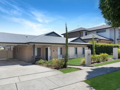 Large SIL house with large driveway and grassed front garden.