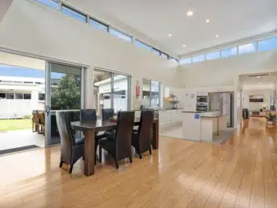 Large open plan kitchen and dining room. There is a large table with chairs in the dining area.