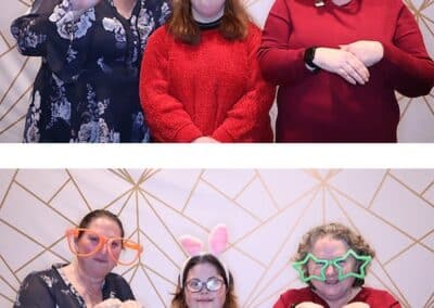 Supported employee, Linda Romig poses with friends in photo booth