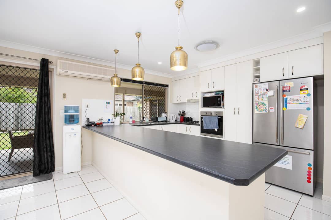 Kitchen with white coloured cabinets and spacious benchtop