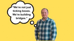 A man wearing a blue checked shirt looks directly at the camera. The words 'We're not just ticking boxes. We're building bridges' appear in a speech bubble next to him.