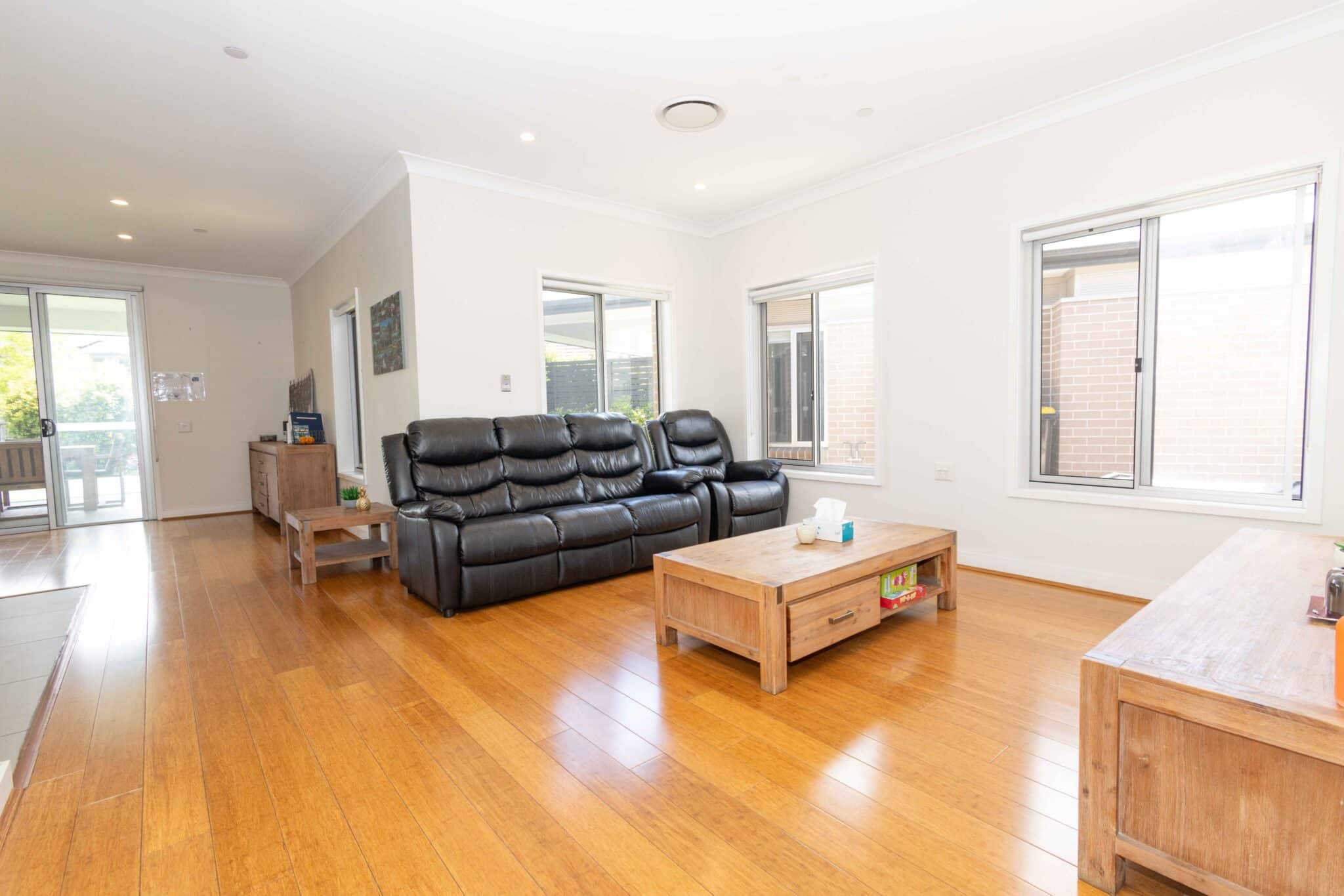 Lounge room with black leather sofas and coffee table