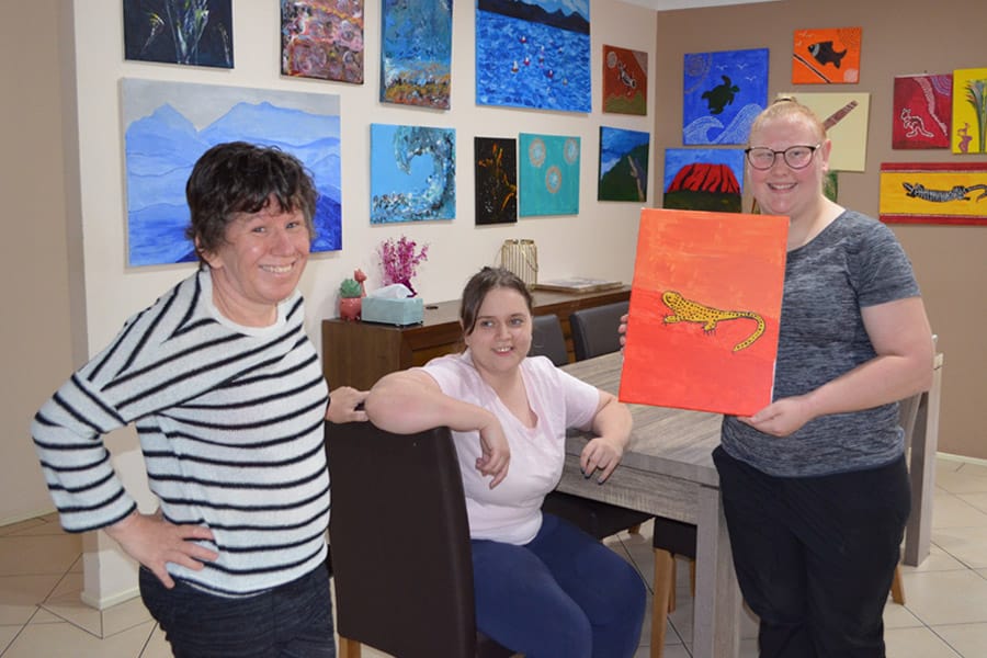 Happy and smiling clients showcasing their artwork