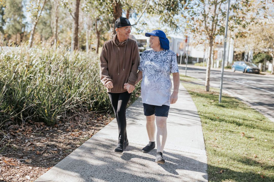 a man and a woman walking outside and holding hands