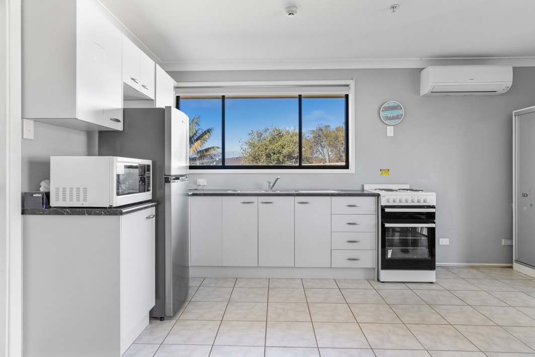Large kitchen with white counters and stainless steel appliances